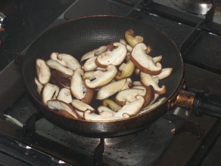 A skillet filled with sliced mushroom